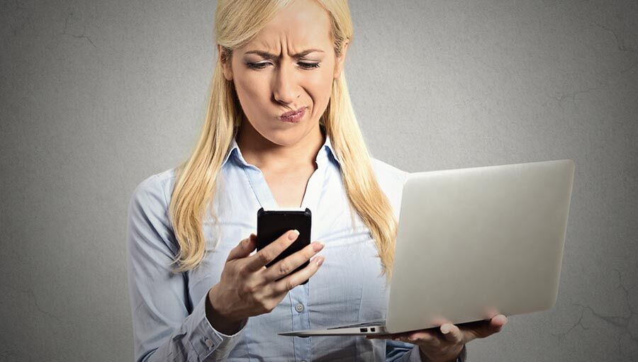 skeptical surprised woman reading news on smartphone holding lap